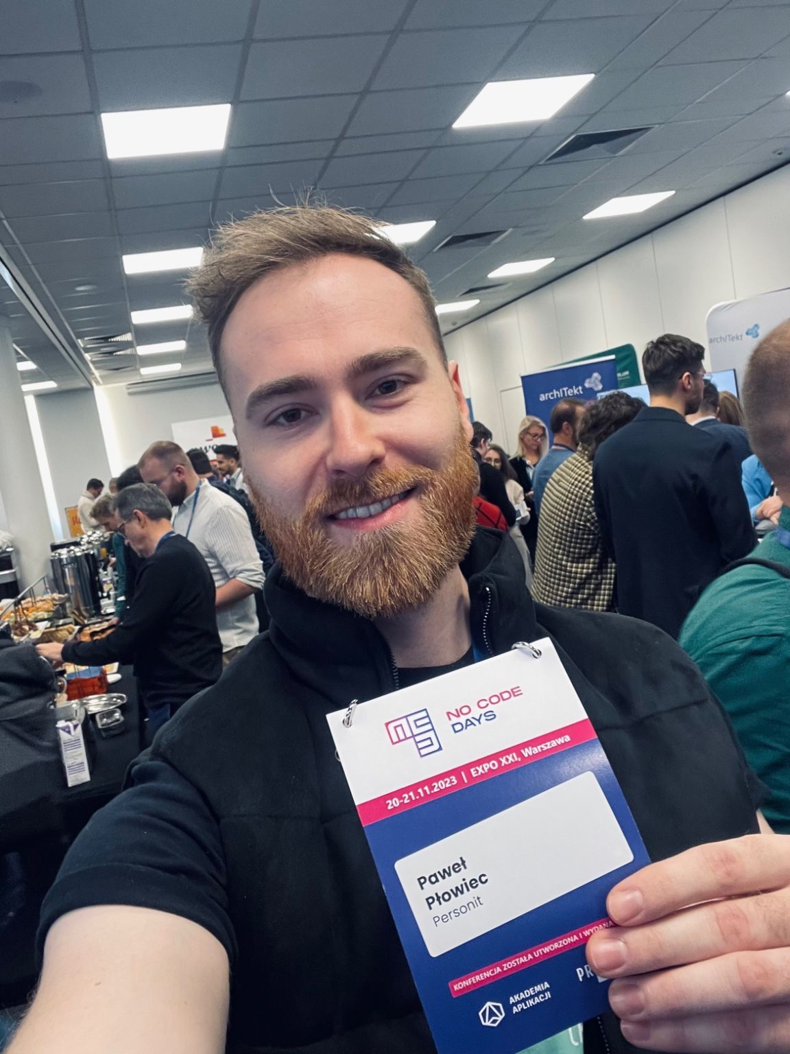 Paweł Płowiec wearing a NoCode Days 2023 badge at EXPO XXI in Warsaw