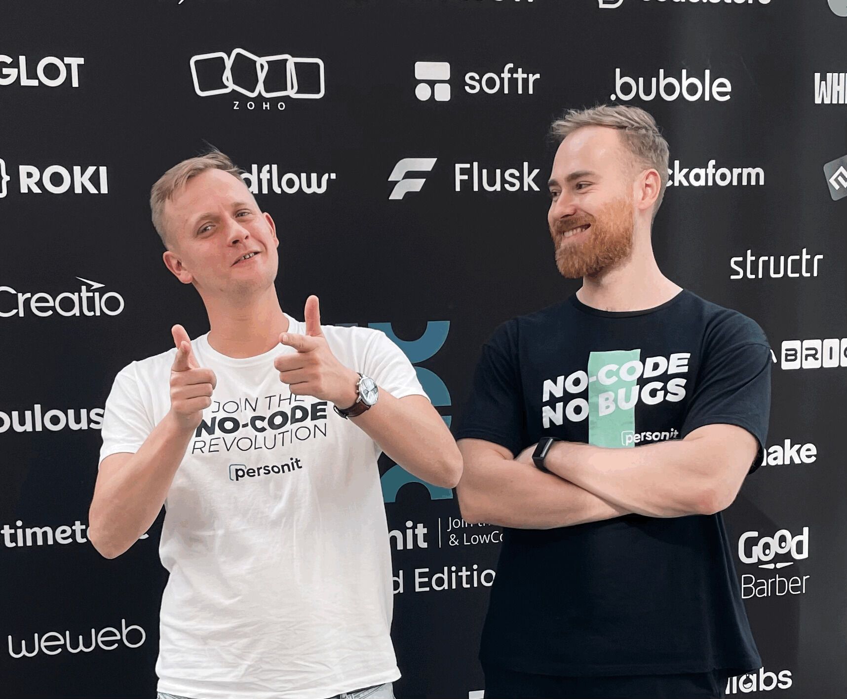 Michał Sukiennik and Paweł Płowiec in front of a wall of no-code tool logos